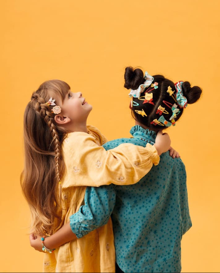 Two children with decorative hair against a yellow background