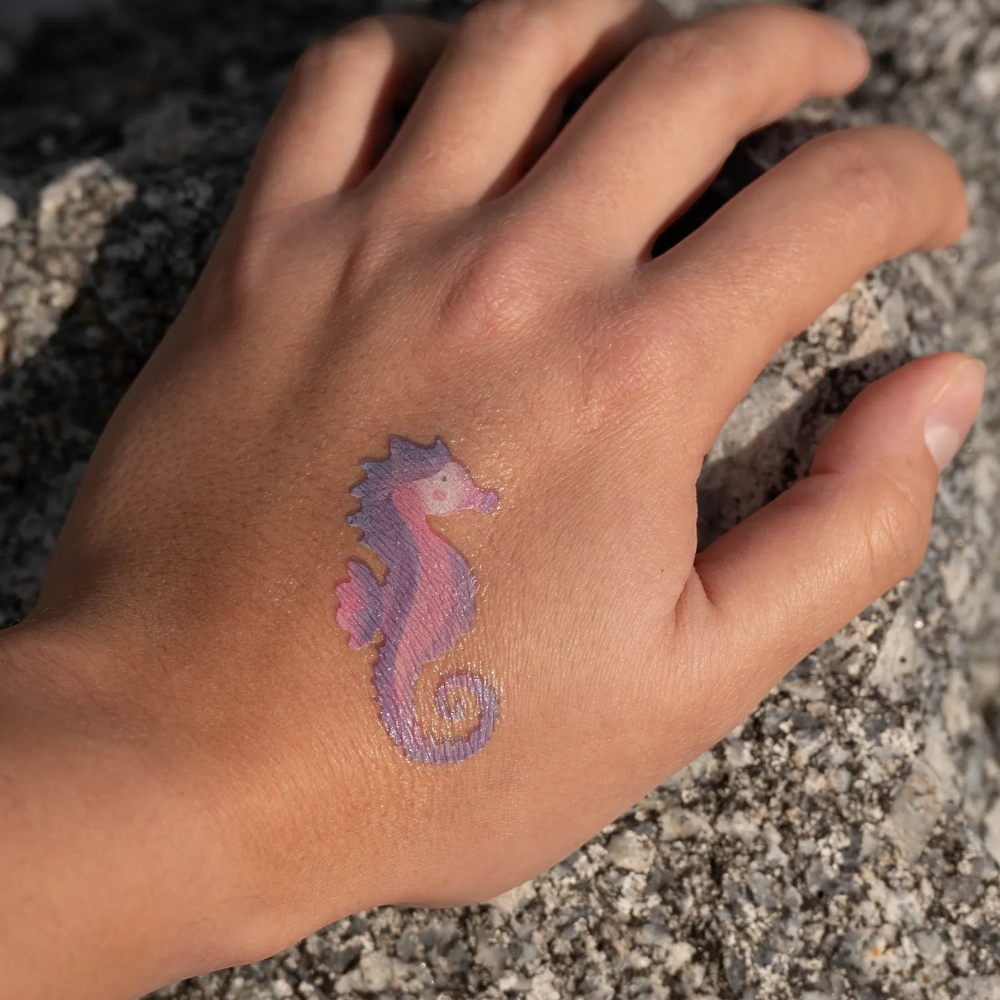 One Two Play Mermaid face paint kit featuring a purple and pink seahorse design applied to a child's hand